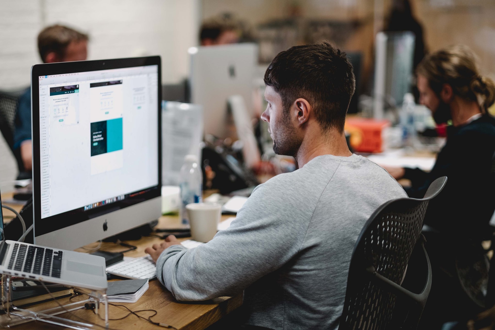 man in grey sweatshirt working on website