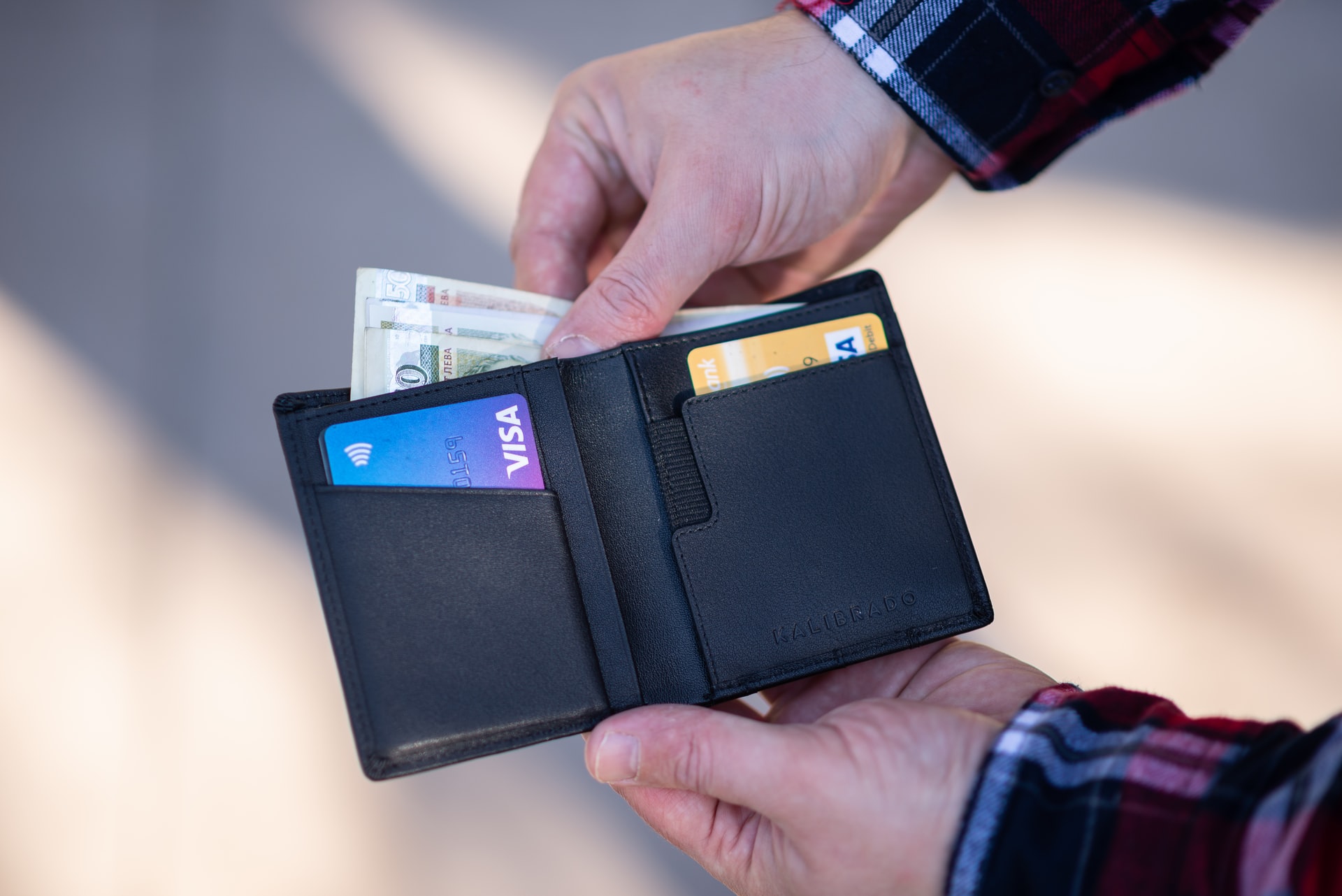 Person taking money out of wallet