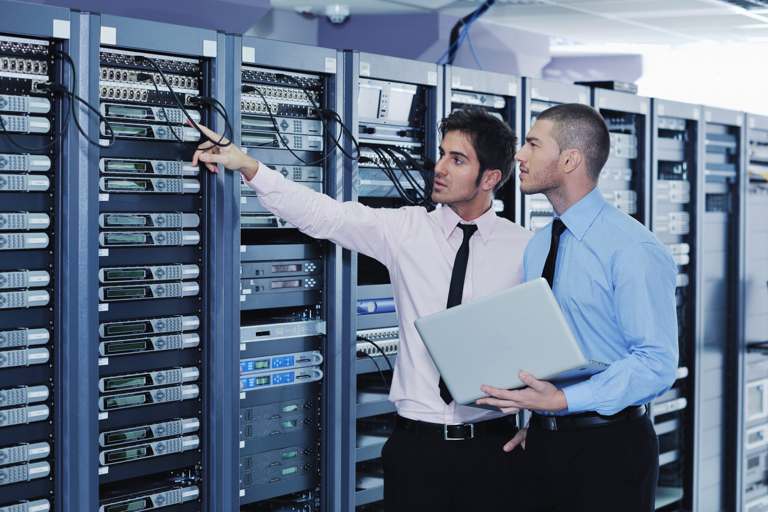 Two men with laptop in server room